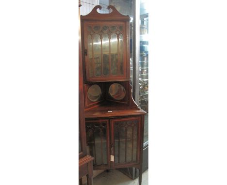 Edwardian strung inlaid and cross-banded two stage, glazed corner cabinet, having broken swan neck pediment above single door