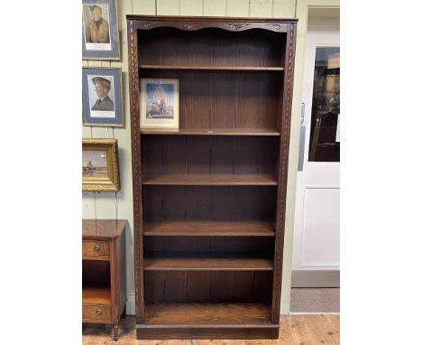 Carved oak open bookcase having four adjustable and one fixed shelf, 199cm by 93.5cm by 32cm.