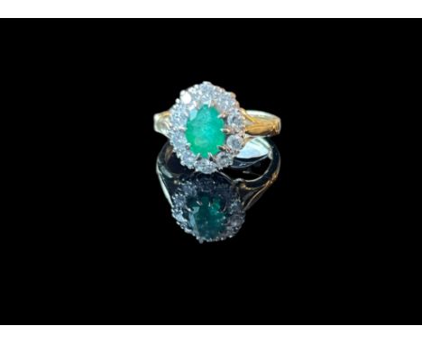 18ct gold diamond and Emerald cluster ring. An oval cut emerald within a surround of brilliant cut diamonds approximately 0.7