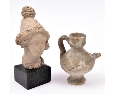 An ancient Roman pottery head, 4¾” x 2¾” of a female, mounted on a square marble base;  also a Roman oil bottle, 3¾” high, GC