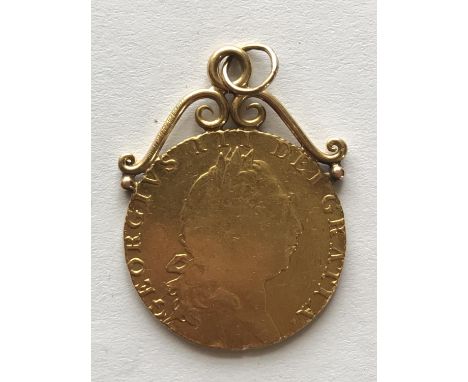 A GEORGE III GOLD GUINEA. A George III Guinea, laureate bust r, reverse with spade shaped shield, dated 1793, with attached l