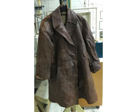AN EARLY 20TH CENTURY BROWN LEATHER FLYING JACKET AND BELT. A full length brown leather flying jacket with double breasted fr