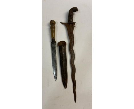 A 19TH CENTURY MALAYAN KRIS TYPE KNIFE AND ANOTHER. A Kris with a 35cm wavy edged tapering blade, the grip in the form of a c