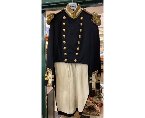 AN EARLY 20TH CENTURY LIEUTENANT COMMANDERS TAIL COAT. A double breasted tail coat with 16 button front, shoulder boards with