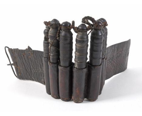 AN UNUSUAL ARM WORN SET OF SEVEN POWDER FLASKS. With seven tapering turned wooden powder tubes, attached by thin rope by the 
