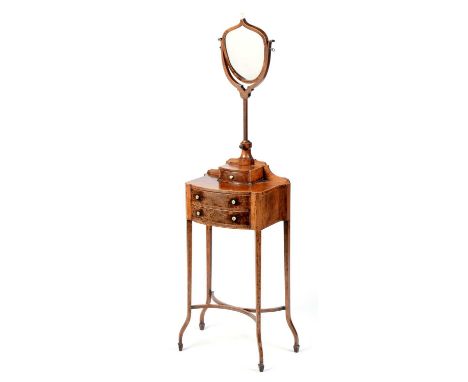 An Edwardian mahogany shaving stand, with an adjustable shield-shaped mirror surmounted by an urn finial and contained within