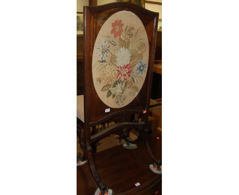 An early 20th century mahogany framed and floral tapestry inset fire screen