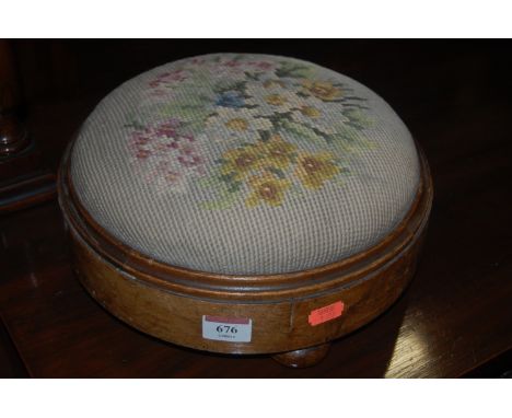 A Victorian figured walnut and floral tapestry embroidered circular low foot stool