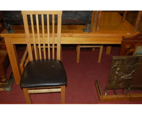 A modern light oak extending dining table, having pull-out action and two extra drop-in leaves; together with a set of four l