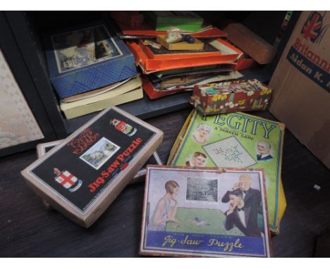 A shelf of vintage games including Parker Pegity and a selection of Chad Valley and Victory jigsaw puzzles etc