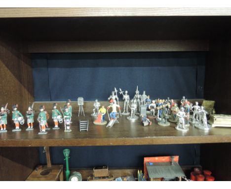 A shelf of cold cast and similar figures including military interest