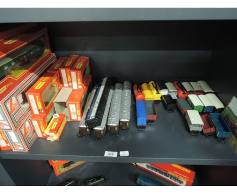 A shelf of mixed OO gauge rolling stock including Triang Hornby, Lima etc, with boxes