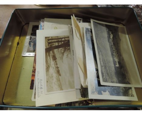 A tin of vintage photographs and postcards