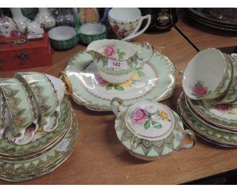 An Imperial part tea service in green and gilt with pink and yellow rose design