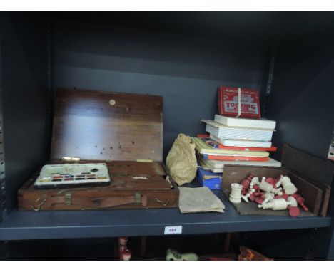 A shelf of mixed toys including a chess set, card games, artists set etc