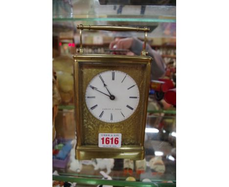 A large antique brass carriage clock, striking on a bell, the enamel dial inscribed 'Osmony a Paris', height including handle