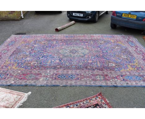 A large Persian rug, having allover floral design, and larger central medallion decorated with flowers, 470 x 312cm.   Condit