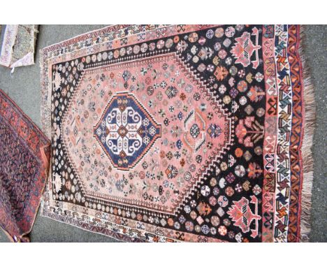 An Eastern wool rug having geometric design on red and brown ground; together with another rug on red ground having geometric