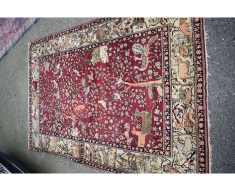 A Persian rug having floral borders, decorated animals, birds and trees, 209 x 138cm.