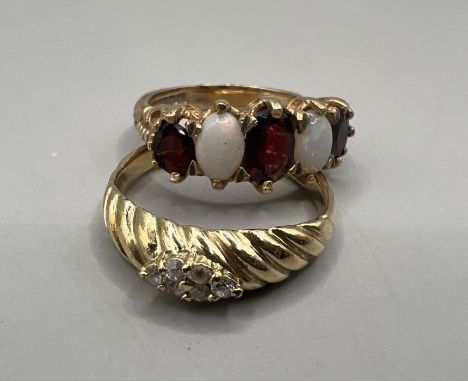 Two dress rings: An opal and garnet set 9ct gold half hoop ring, approximate gross weight 4.3 grams, size N; plus a yellow me