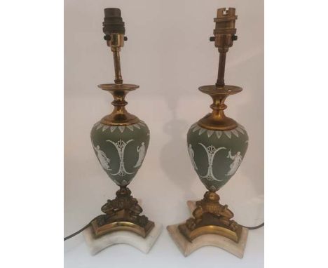 A matched pair of Wedgwood porcelain bodied and brass fitted lamps, raised on lions paw tripod foot.40cm high. One lamp body 