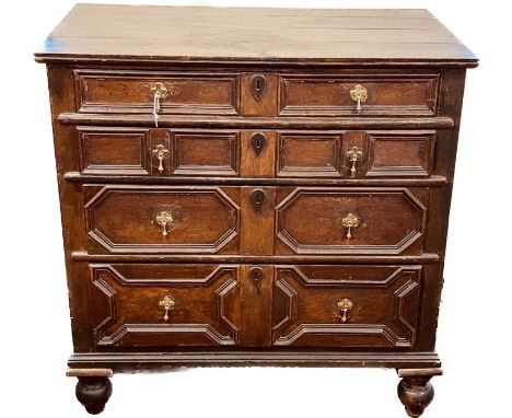 A Charles II oak chest of drawers, four plank top, circa 1660, above four moulded geometric gradual drawers with brass teardr