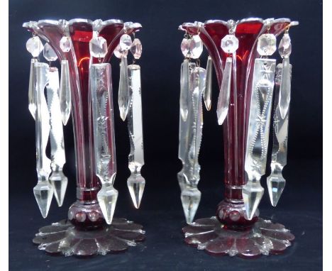 A pair of 19th century Bohemian ruby and clear glass table lustres hung with prismatic drops, shaped circular bases, 27cm hig