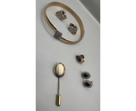 A selection of yellow metal jewellery items comprising three pairs of studs, a cubic zirconia set bangle and a gold plated st