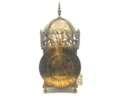 A 17th century revival brass lantern clock, mounted with vase finials,&nbsp;beneath domed bell bearer capped, flanked by fleu