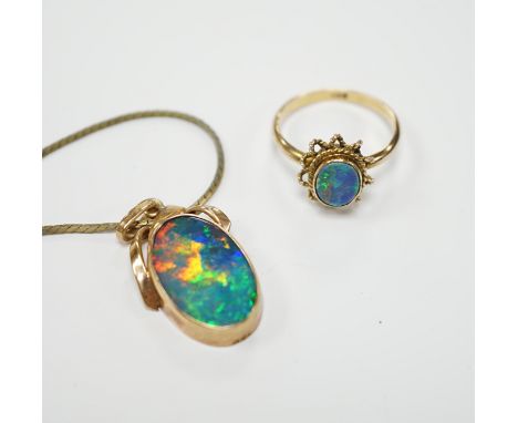 A 9ct and black opal doublet set oval ring, size L and a yellow metal and black opal doublet set pendant, on a gilt metal cha