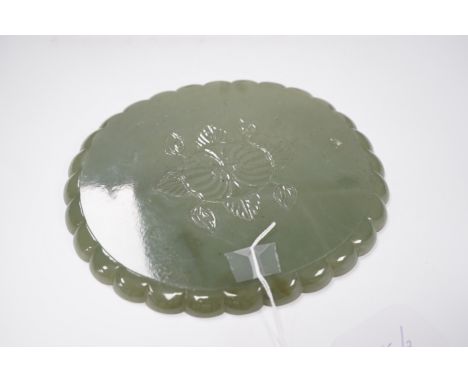 A Mughal style oval celadon jade dish, with petal lobed rim the underside carved with leaves, wood stand, 20cm***CONDITION RE