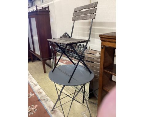A painted wrought iron circular garden table, diameter 59cm, height 72cm and two slatted folding chairs***CONDITION REPORT***