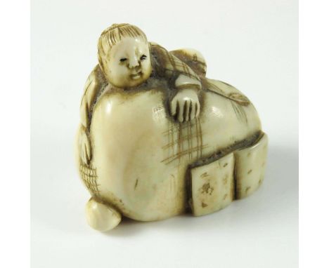 JAPANESE MEIJI PERIOD NETSUKE DEPICTING A MAN CLIMBING ONTO A SACK, APPROX. 3.4 cm W.