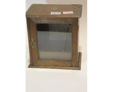 Early 20th century oak smokers cabinet with single glazed door, integral two section pipe rack and silver plated mounts, date