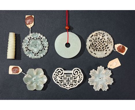 SEVEN CARVED AND PIERCED JADE PLAQUES AND CARVINGS Comprising: a disc with archaistic shallow relief decoration; three floral