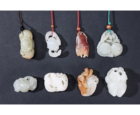 A GROUP OF EIGHT JADE CARVINGS AND TOGGLES To include an example with a frog, sat on a lotus; one carved as two crabs; two an