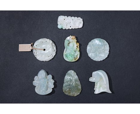 A GROUP OF SEVEN CARVED JADE PENDANTS
Including an an example of a boy within a gourd shaped pendant; Guanyin with an attenda