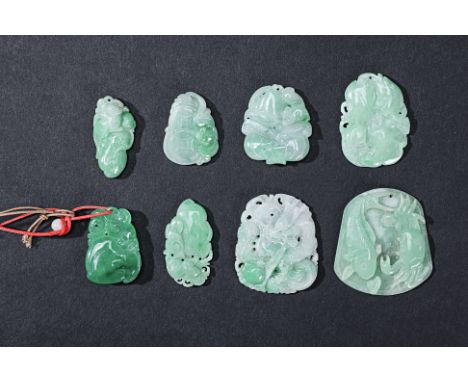 A GROUP OF EIGHT CARVED JADE PENDANTS One carved with a fish and a crab; one with a dragon; various examples with fruit etc. 