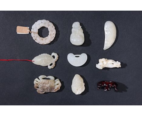 A GROUP OF EIGHT ASSORTED JADE CARVINGS
To include a disc carved and pierced with bats; a padlock shaped pendant; a figure ho