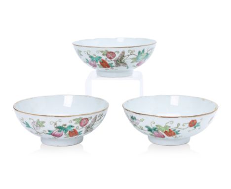 A SET OF THREE FAMILLE ROSE PORCELAIN BOWLS Decorated with butterflies amongst fruiting and flowering vines, iron red peach m
