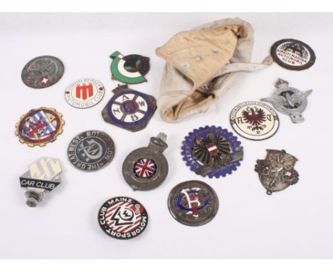 Fourteen mid 20th Century car badges including founder member of the Jaguar SS Car Club and a white leather driving helmet