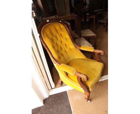 A Victorian mahogany framed open armchair, button upholstered in a gold velour, scroll arm terminals, on turned supports