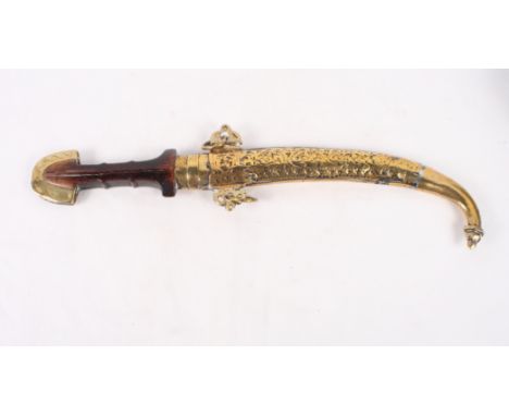 An Arabian jambiya with hardwood handle and embossed brass scabbard, blade 9" long