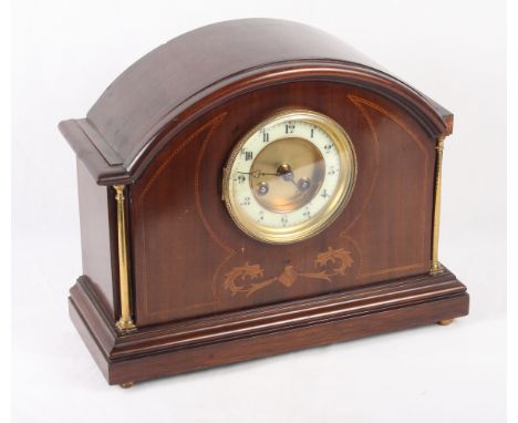 An Edwardian mahogany and inlaid arch top mantel clock with brass flanking columns, 10 1/2" high