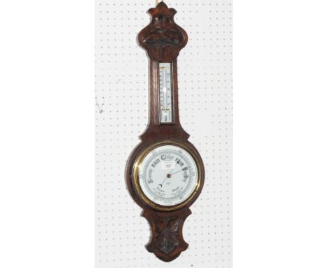 An aneroid barometer and thermometer in carved oak case