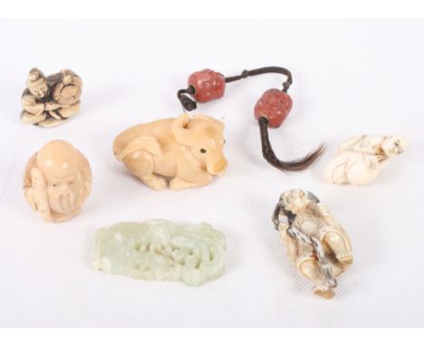A Japanese okimono of a sage with a stick, 2" high, a carved walnut netsuke of a buffalo, 2" long, a similar netsuke of Lao T