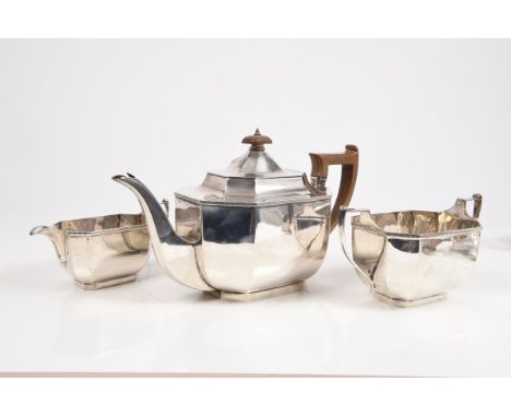 1920s three piece silver tea set of faceted form, comprising teapot with punched and engraved border, angular fruitwood handl