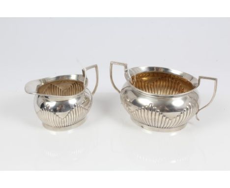 Late Victorian silver two-handled sugar bowl of oval form, with fluted decoration and flared rim, on an oval foot, underside 