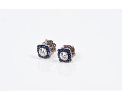 Pair diamond and sapphire earrings, each with an old cut diamond and border of calibre cut blue sapphires, all in millegrain 