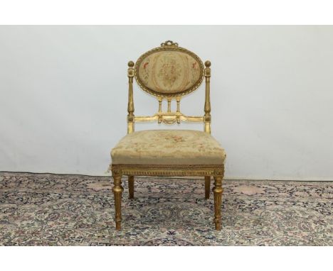 Early 20th century giltwood side chair with ribbon cresting, oval tapestry padded back and tapestry seat on fluted turned fro